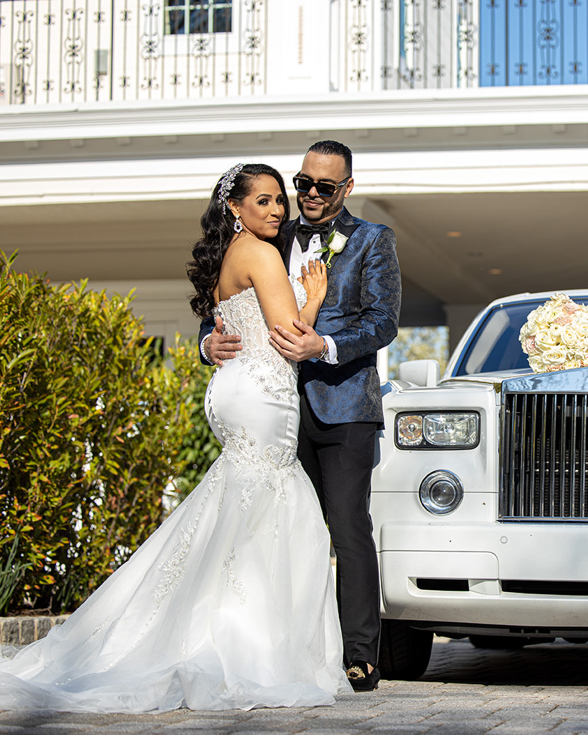 Bride and Groom posing next to a car at The Wedding
